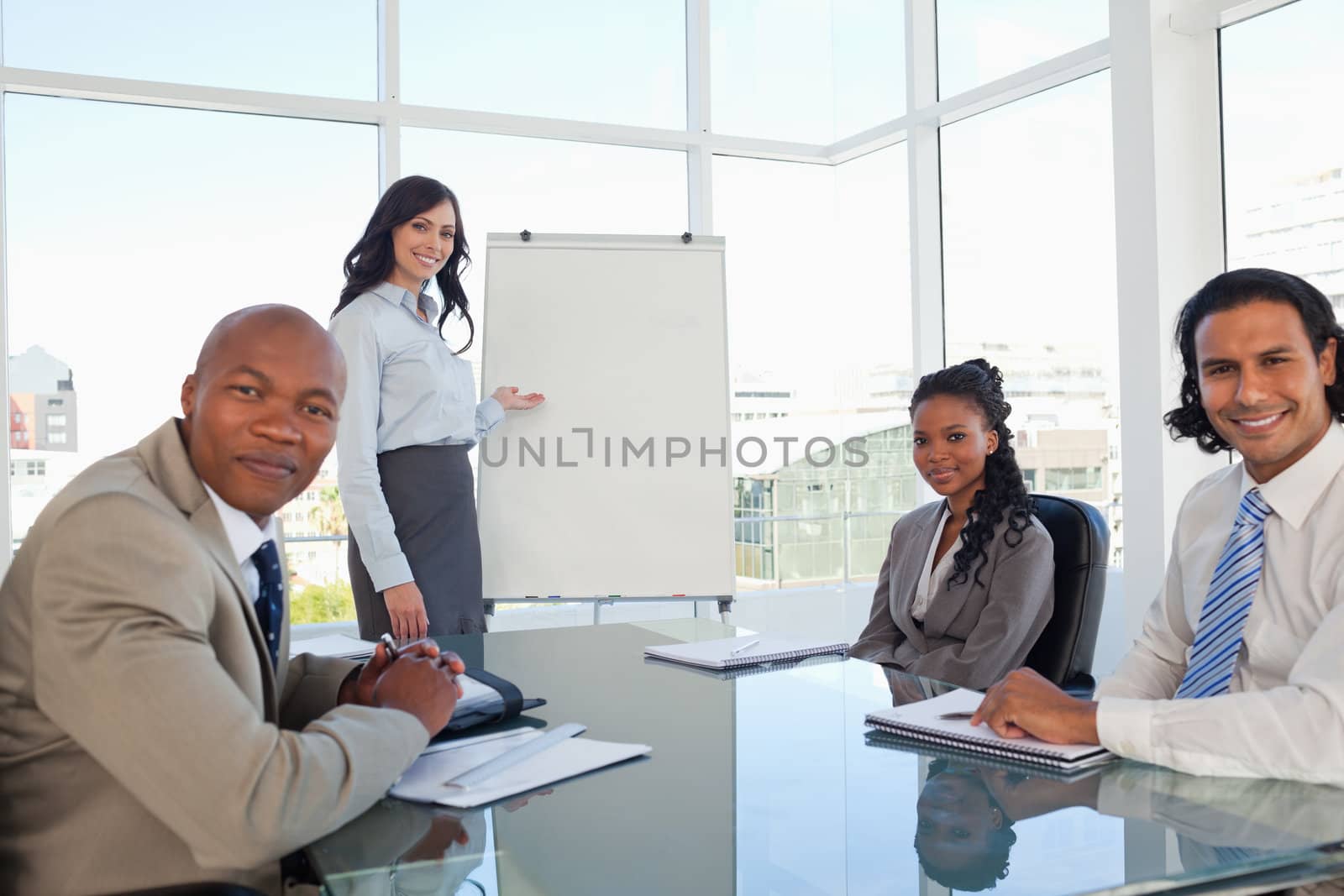 Smiling executive woman giving a presentation to her relaxed coworkers