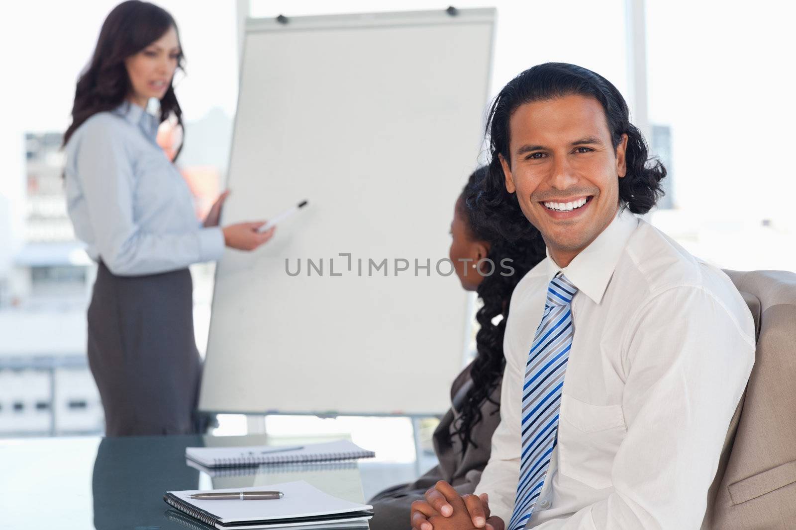 Young employee smiling during a presentation while his team is w by Wavebreakmedia