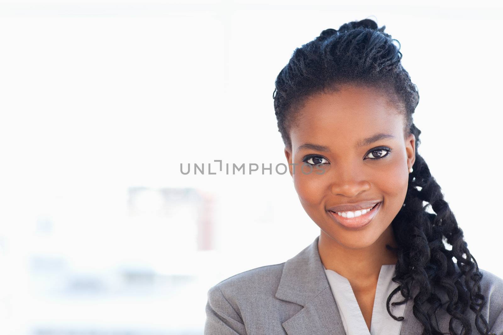 Young employee standing upright in front of a bright window whil by Wavebreakmedia