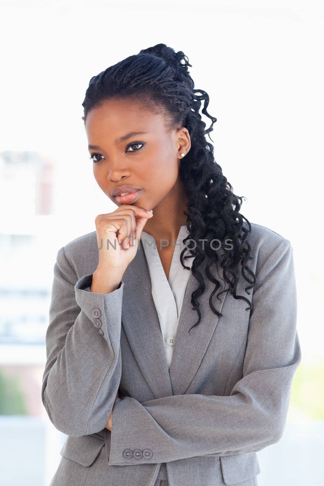 Businesswoman looking towards the side with her hand on her chin by Wavebreakmedia
