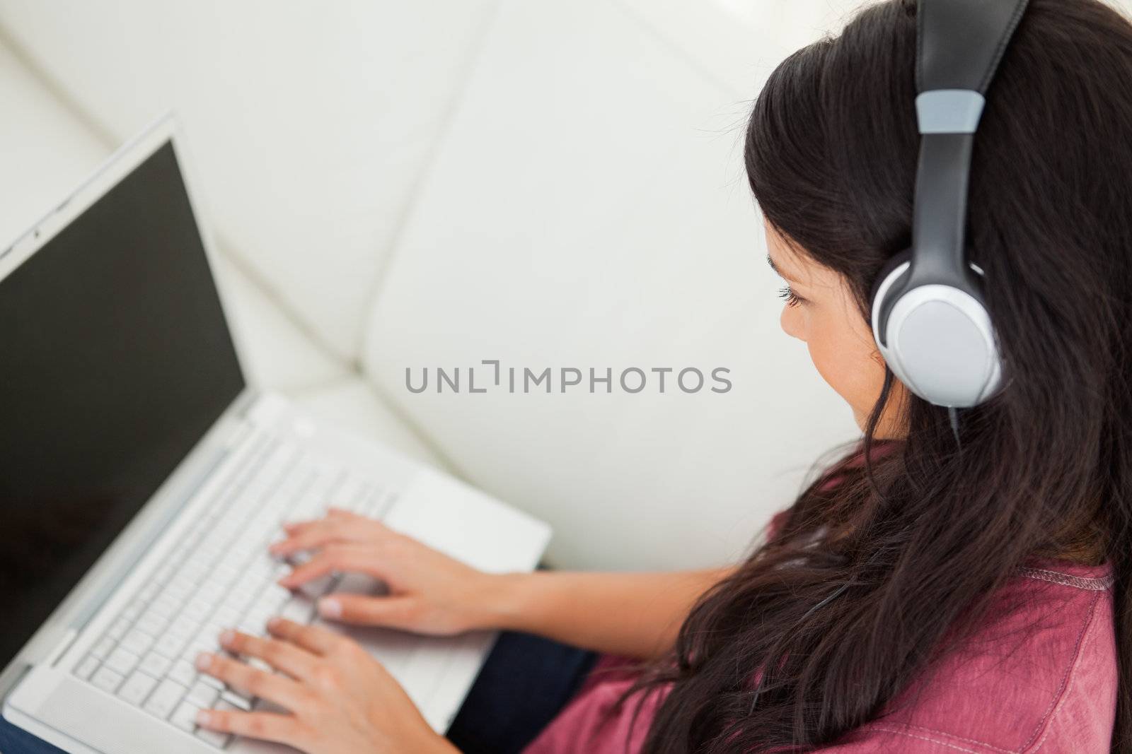 High-angle view of a student using her laptop on the sofa