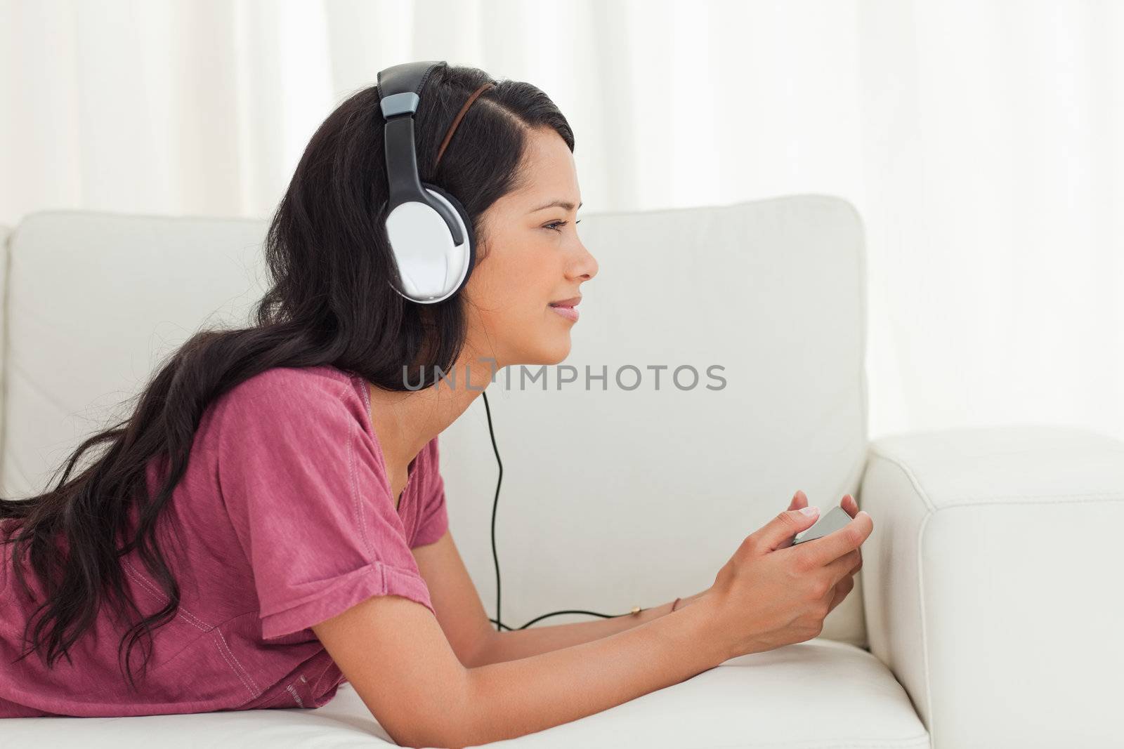 Cute Latino listening to music with her smartphone by Wavebreakmedia