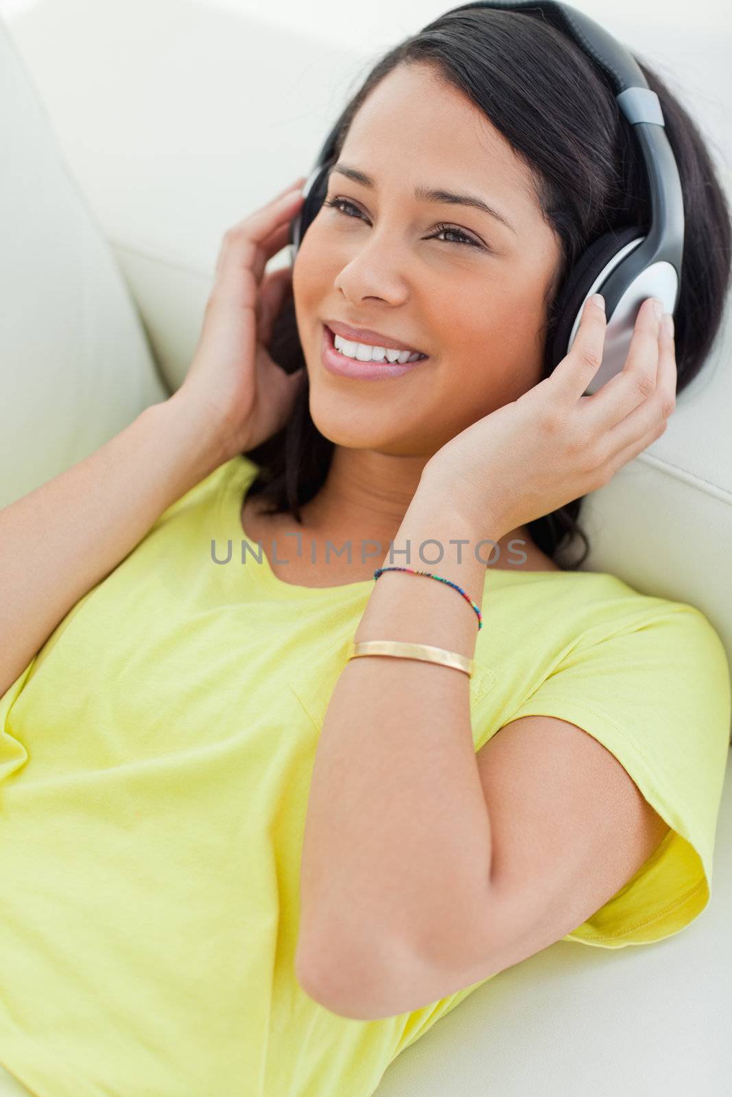 Close-up of a smiling Latino listening music on a smartphone by Wavebreakmedia
