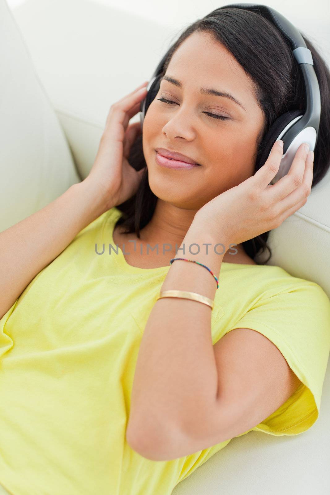 Close-up of a smiling Latino enjoying music on a smartphone by Wavebreakmedia