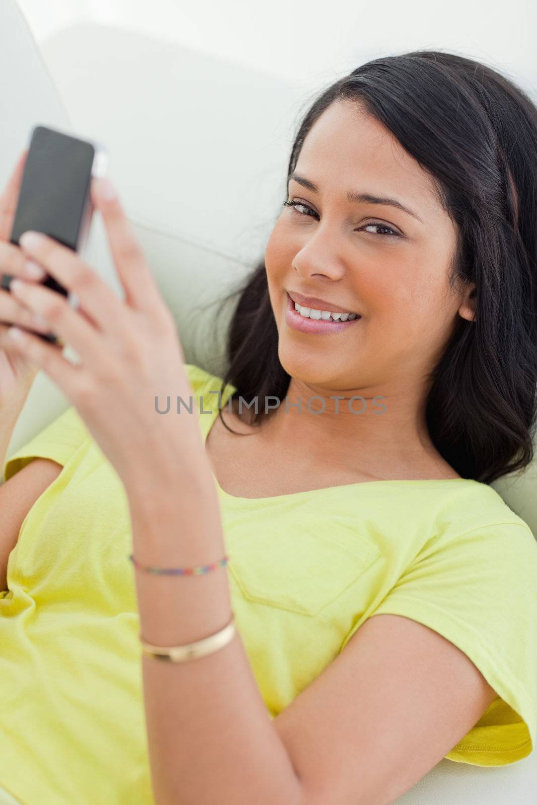 Portrait of a Latino holding her smartphone by Wavebreakmedia
