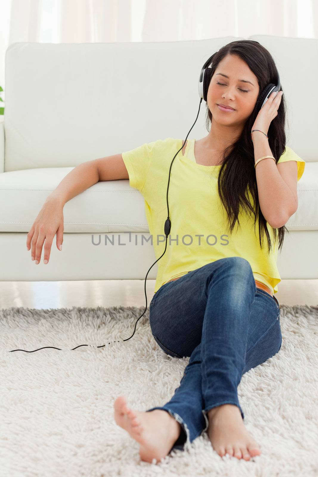 Beautiful Latin enjoying music while sitting on the floor