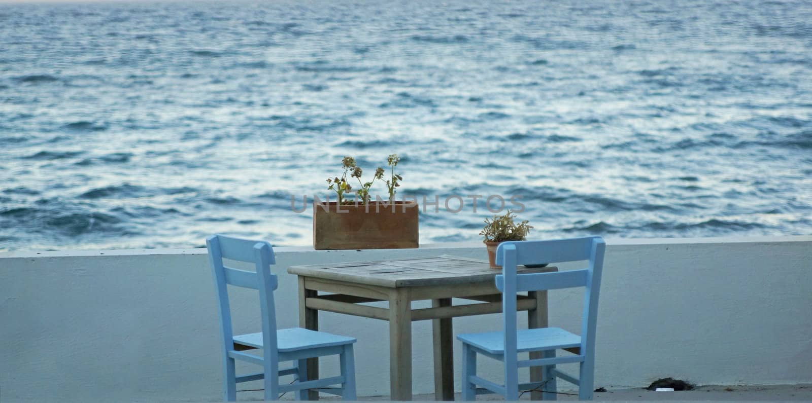 Wooden chair and table by the sea  with flowers