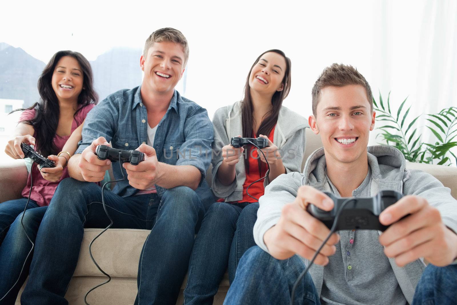 A group of friends playing games and laughing sit in front of the camera