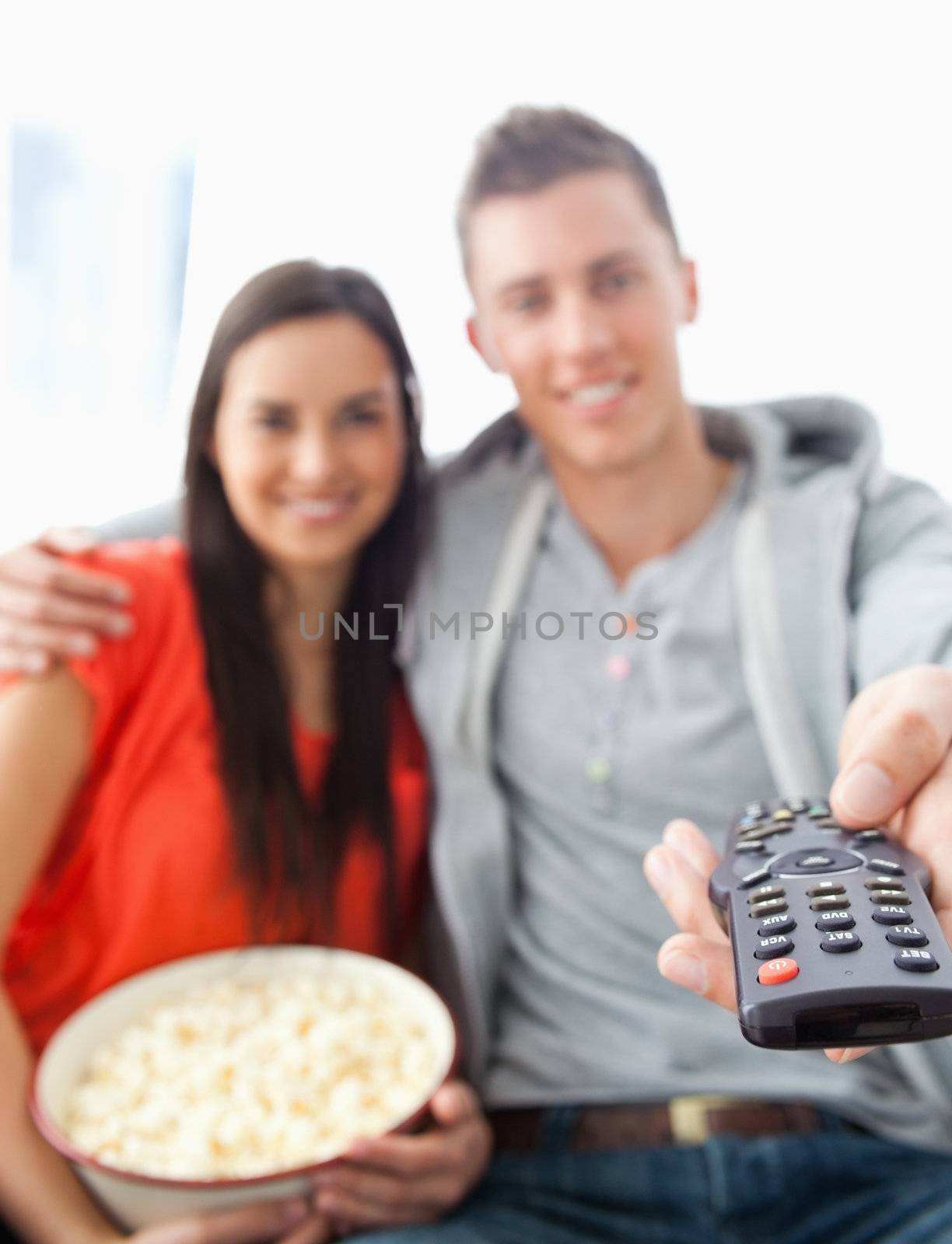 Close up focus shot of a tv remote in the man's hand by Wavebreakmedia