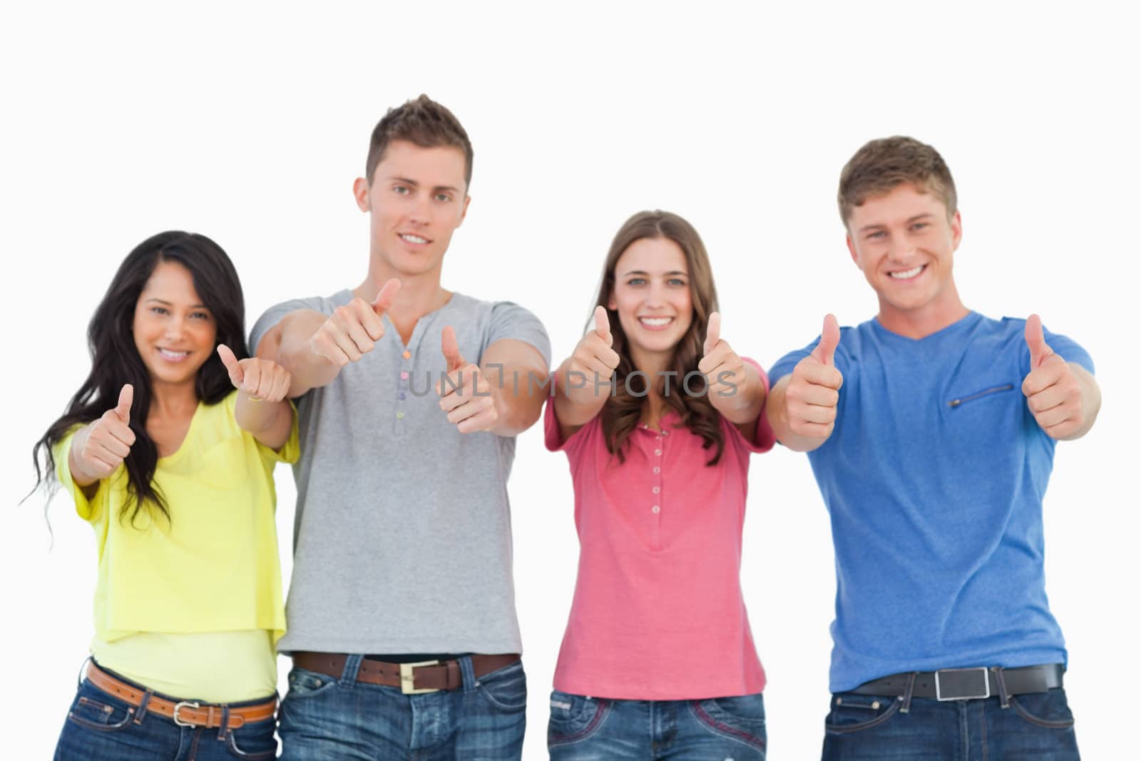 A smiling group of friends give a thumbs up while looking at the camera 