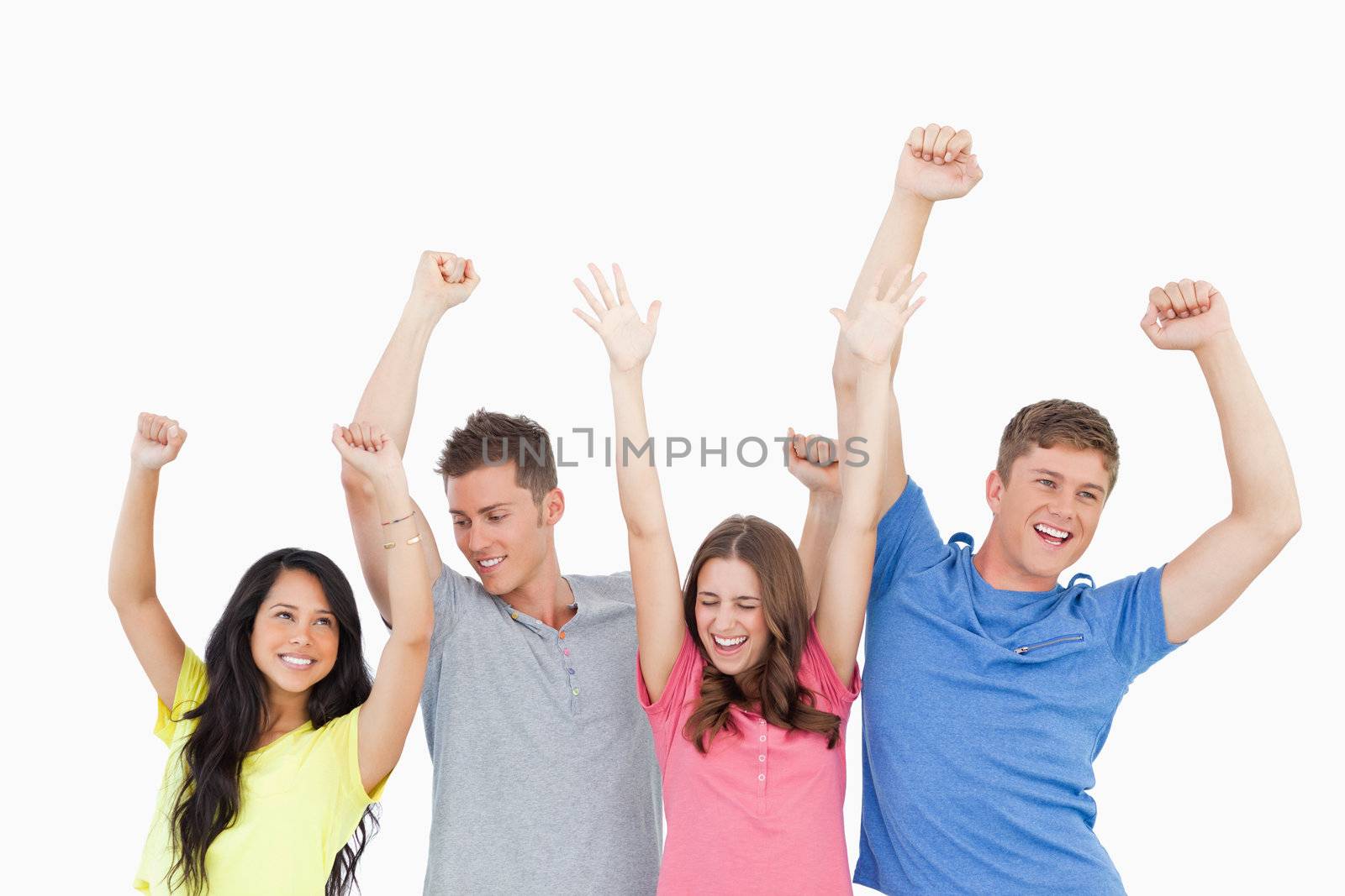 A group of friends party together with their hands in the air