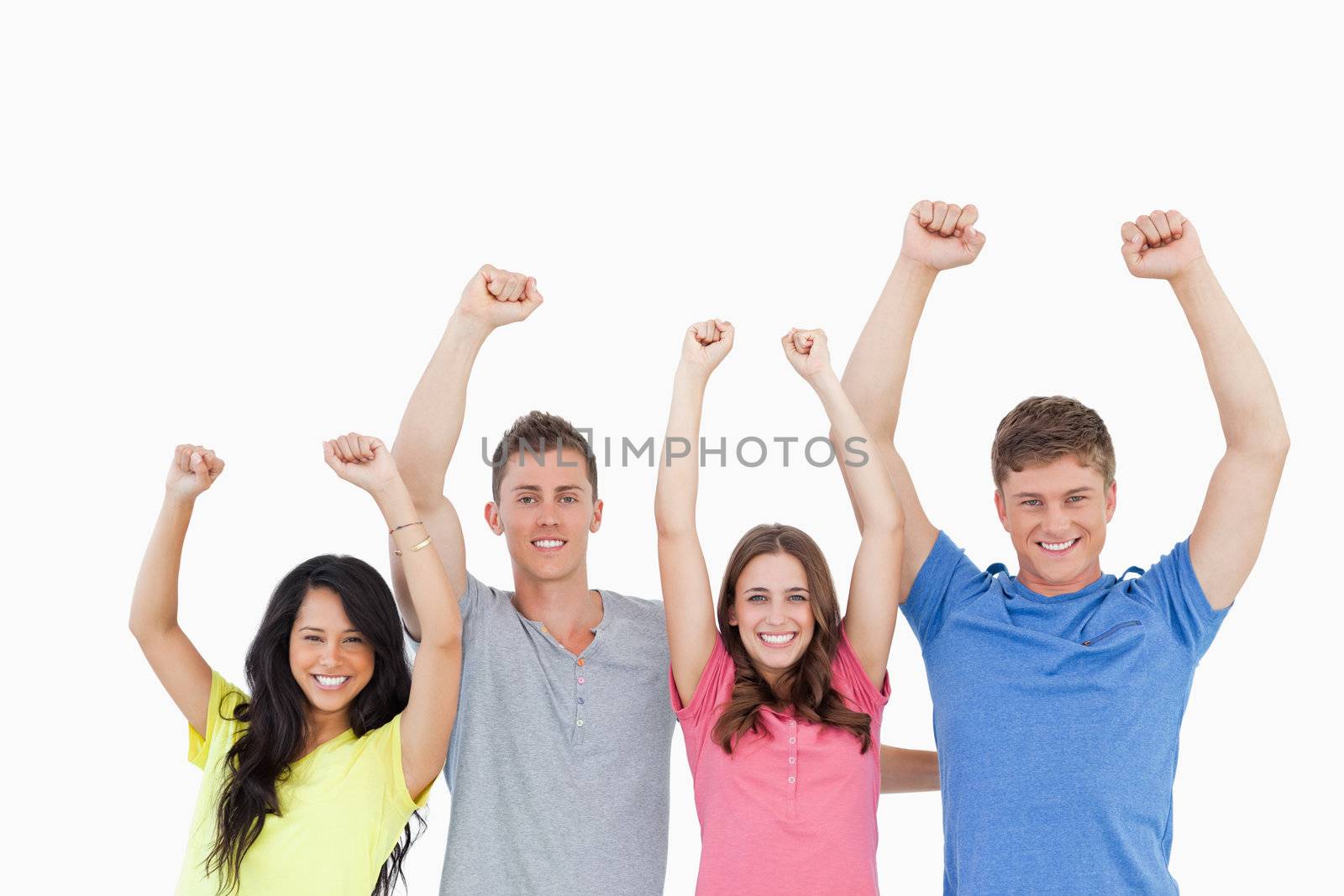 A smiling group as they celebrate with their hands raised in the air 