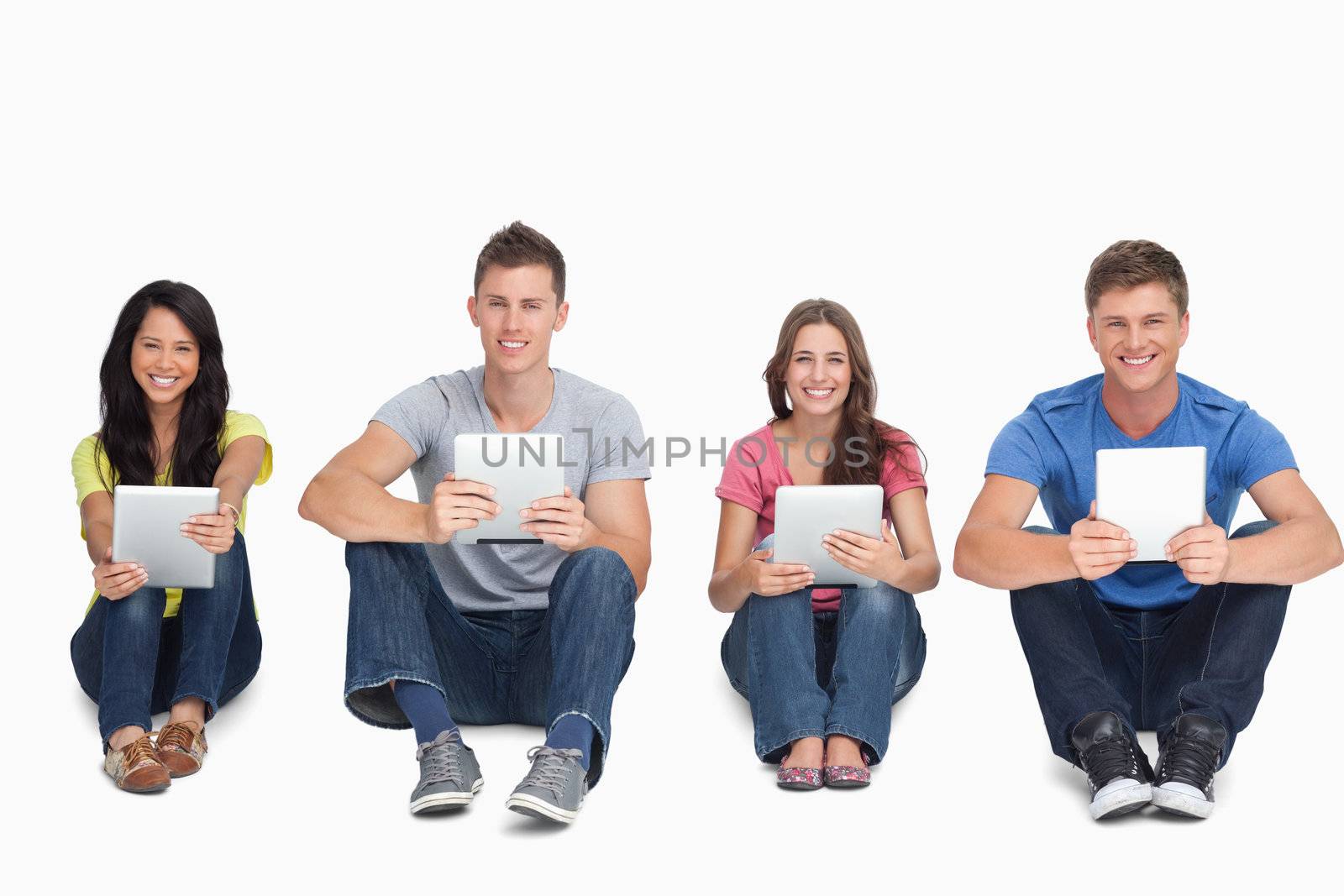 A group of people holding their tablet pc's in their hands as they all look at the camera