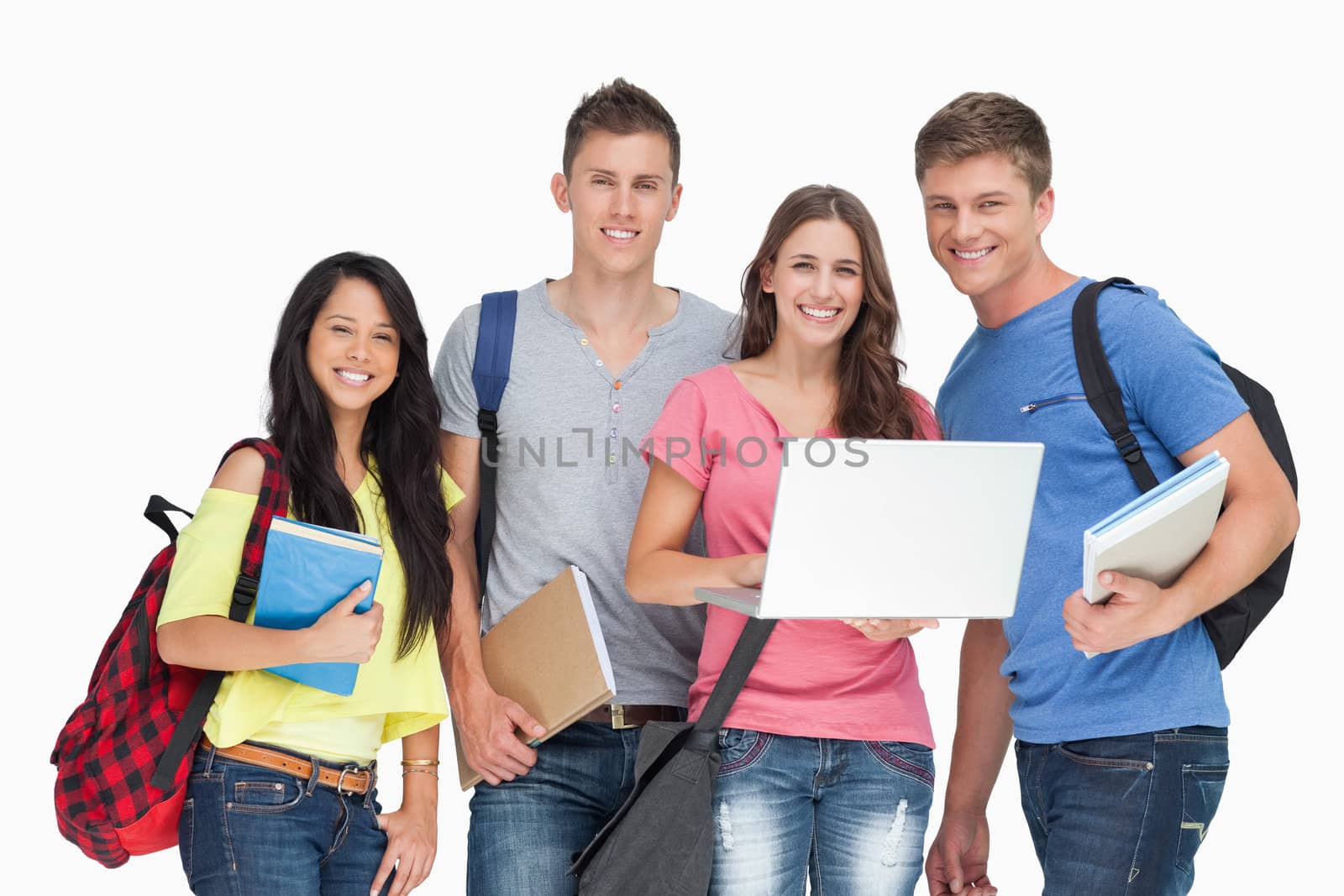 A group of smiling students looking at the camera while one holds a laptop 