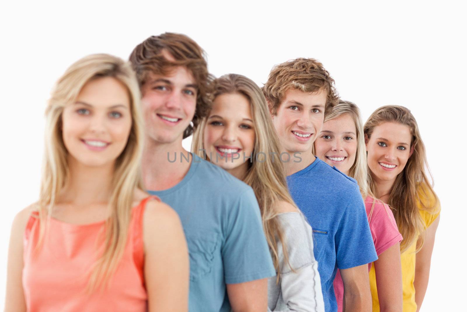 A smiling group standing behind each other while looking at the camera 