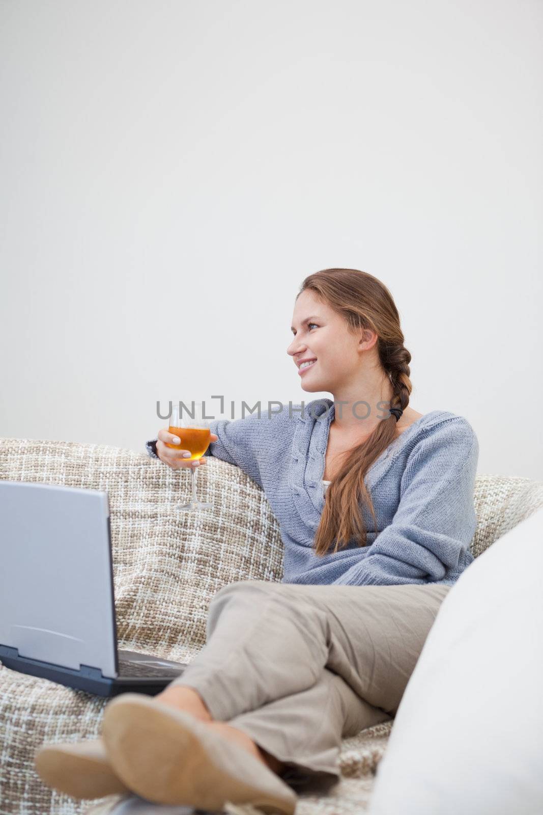 Woman sitting while holding a glass by Wavebreakmedia