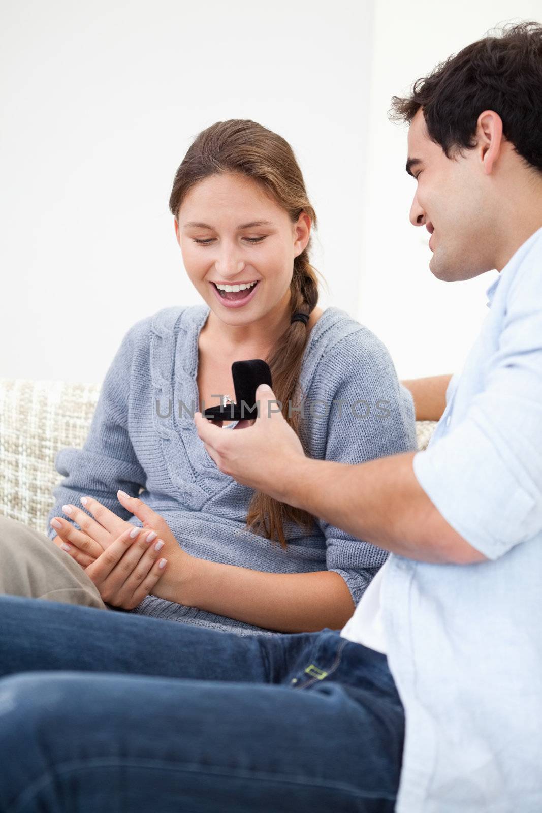 Man offering a ring to a Woman against grey background