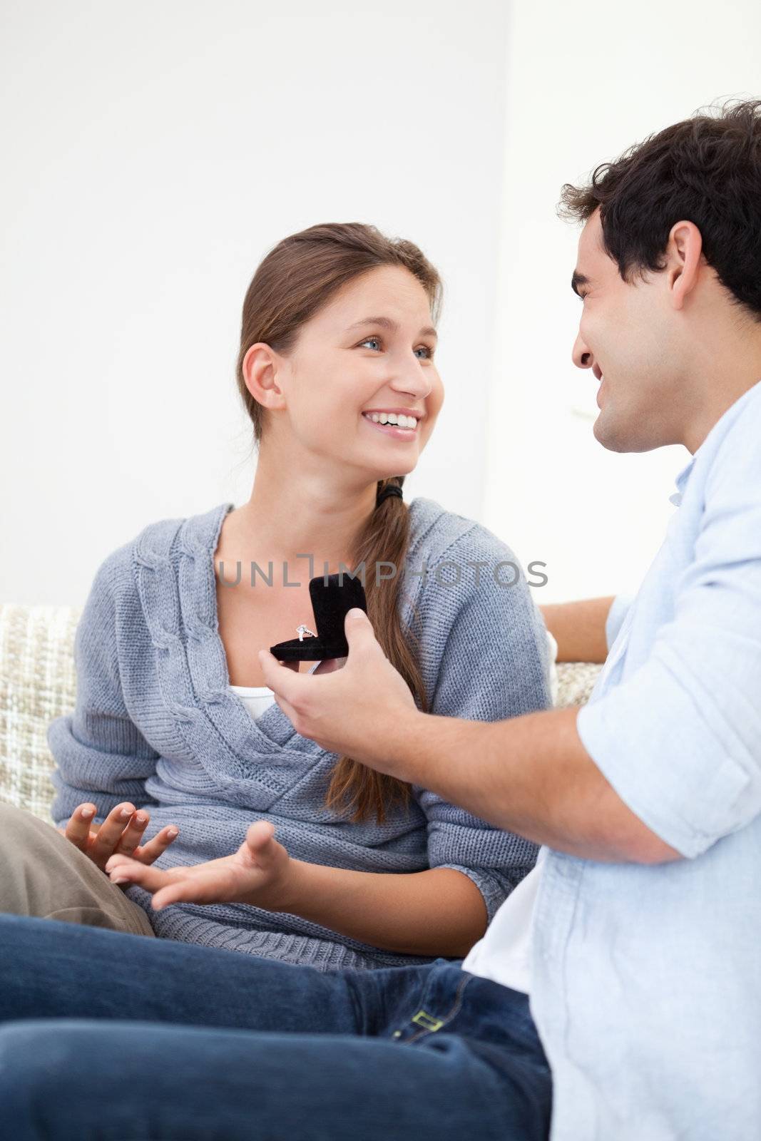 Man offering a ring to a Woman while sitting by Wavebreakmedia