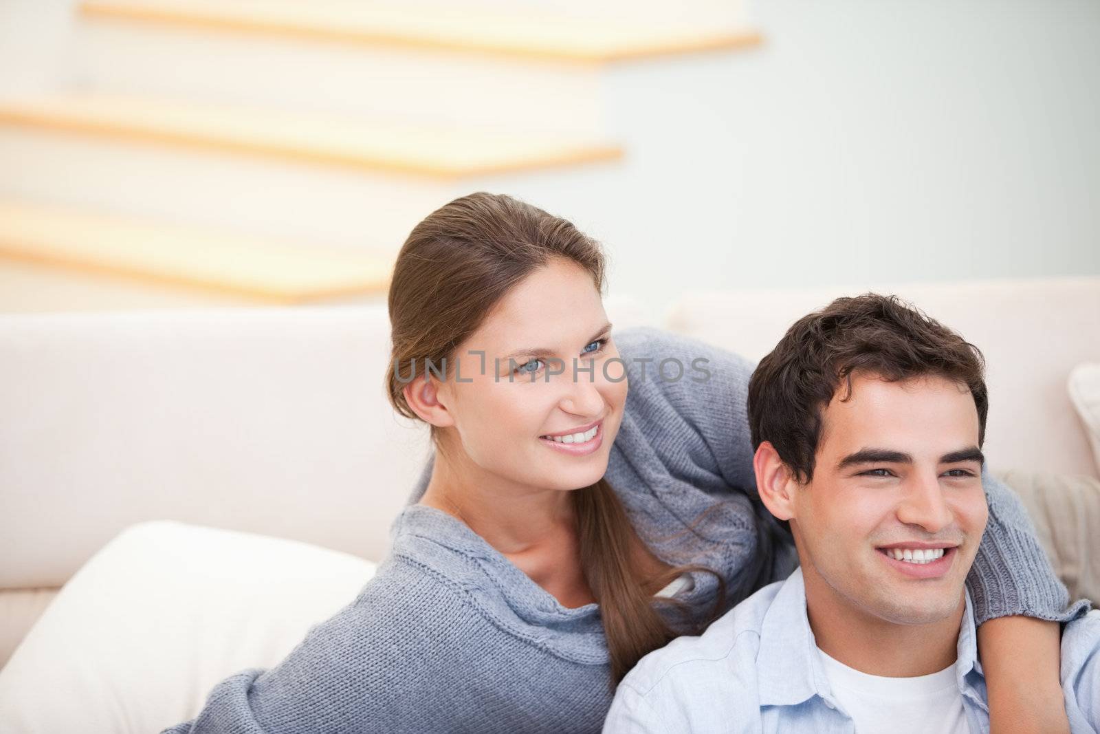 Couple looking away while embracing in a sitting room