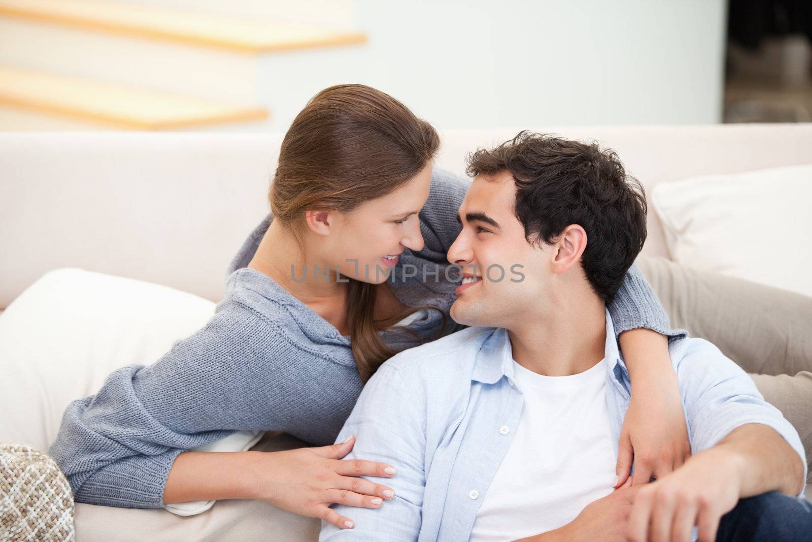 Couple embracing eachother while sitting a sofa in a sitting room