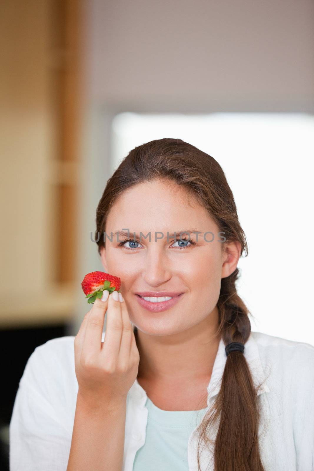 Woman eating a strawberry indoors