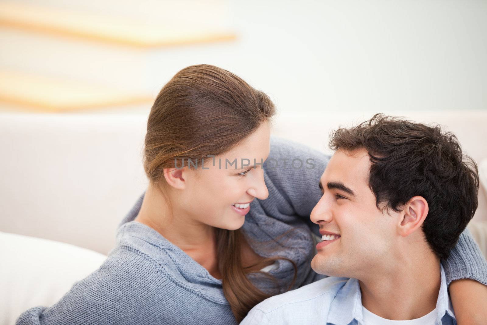 Couple looking each other while embracing in a sitting room