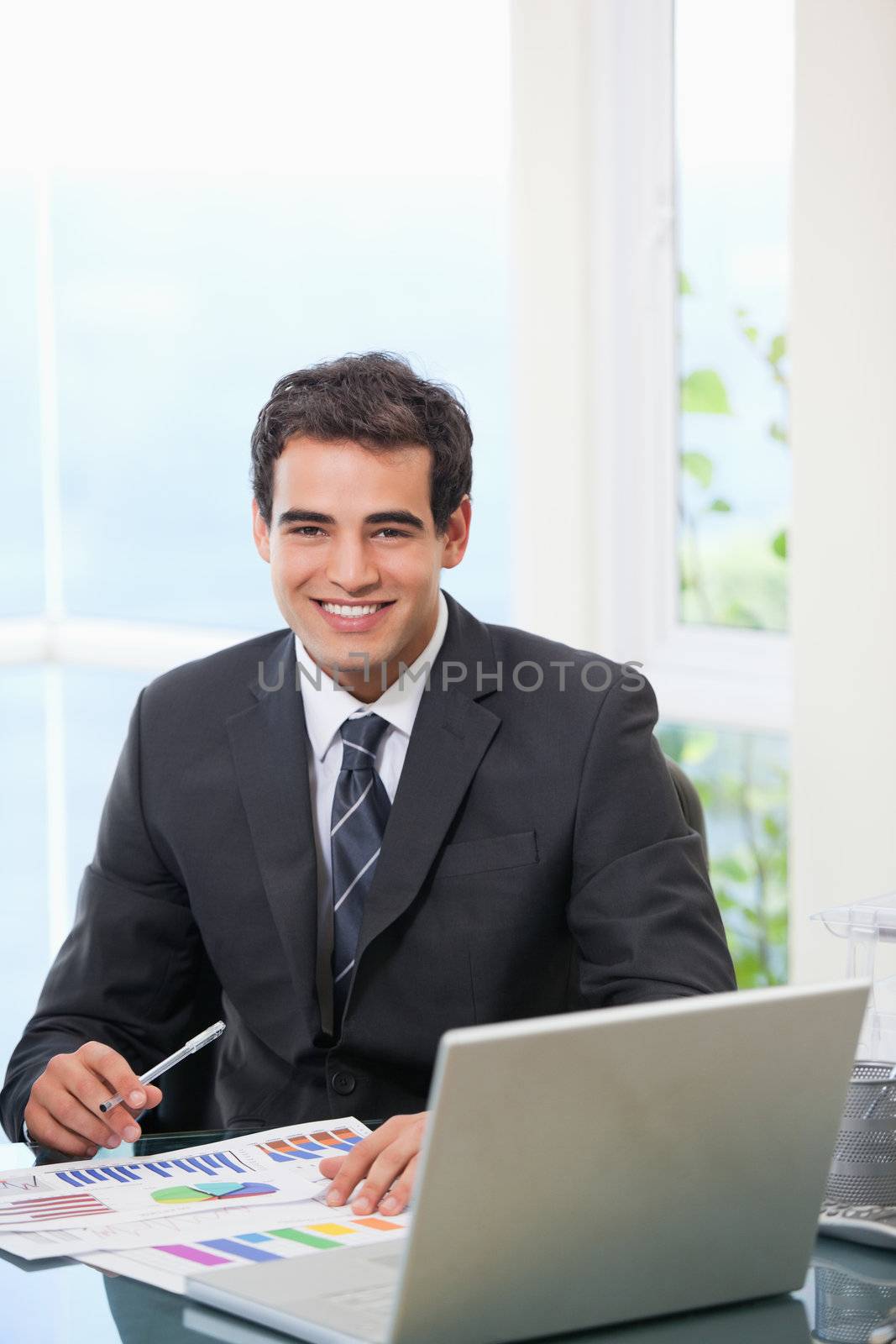Man working on graph while smiling by Wavebreakmedia