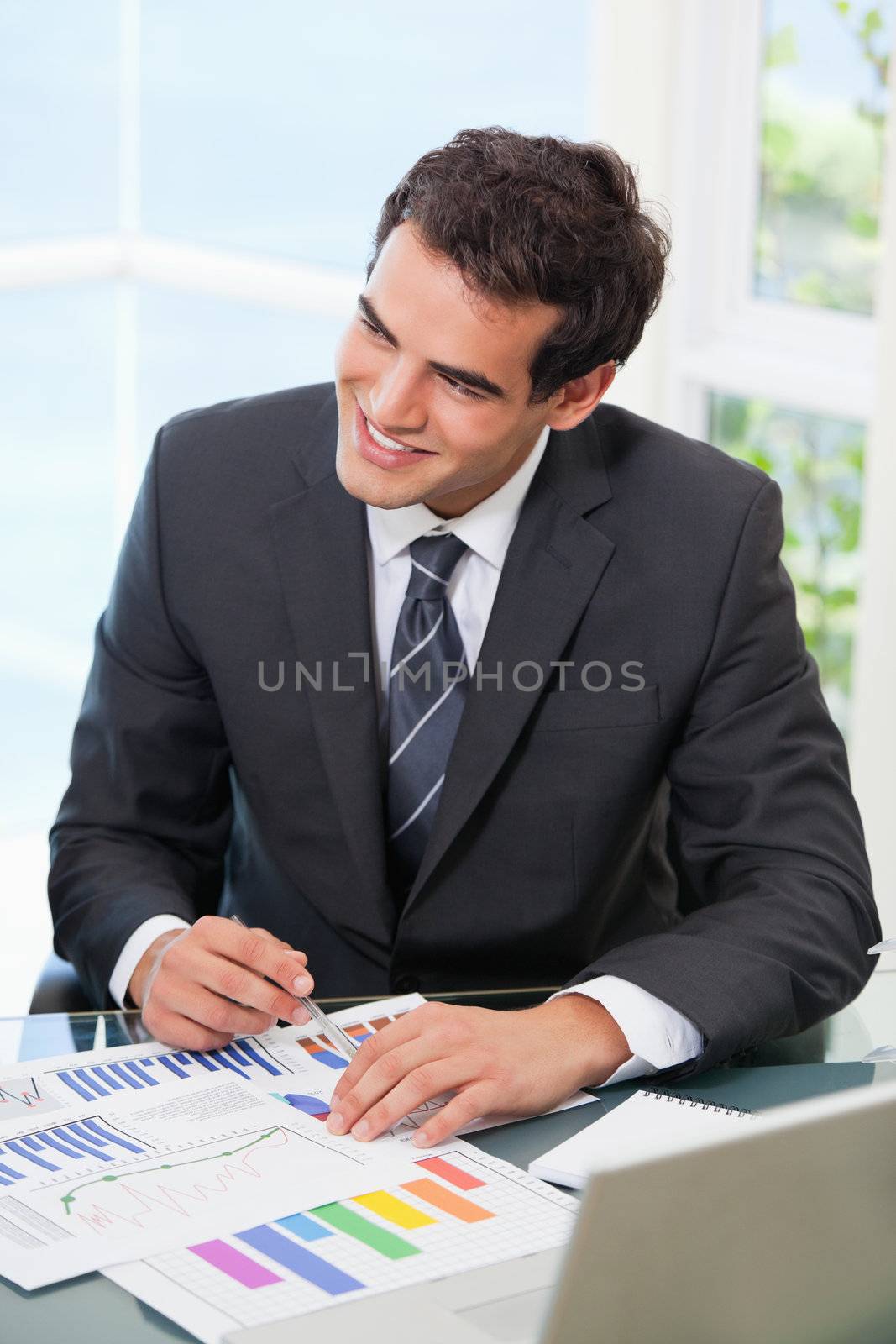 Man pointing out a graph while looking away in an office