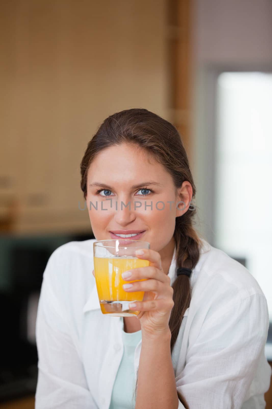 Woman drinking orange juice in a kitchen