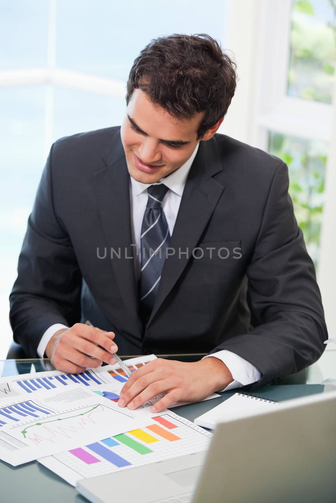Man sitting on a chair while looking at graph in an office