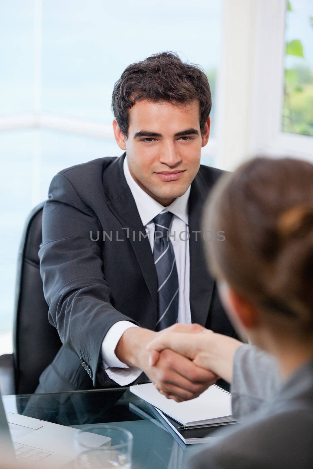 Businessman shaking hands with a Businesswoman by Wavebreakmedia