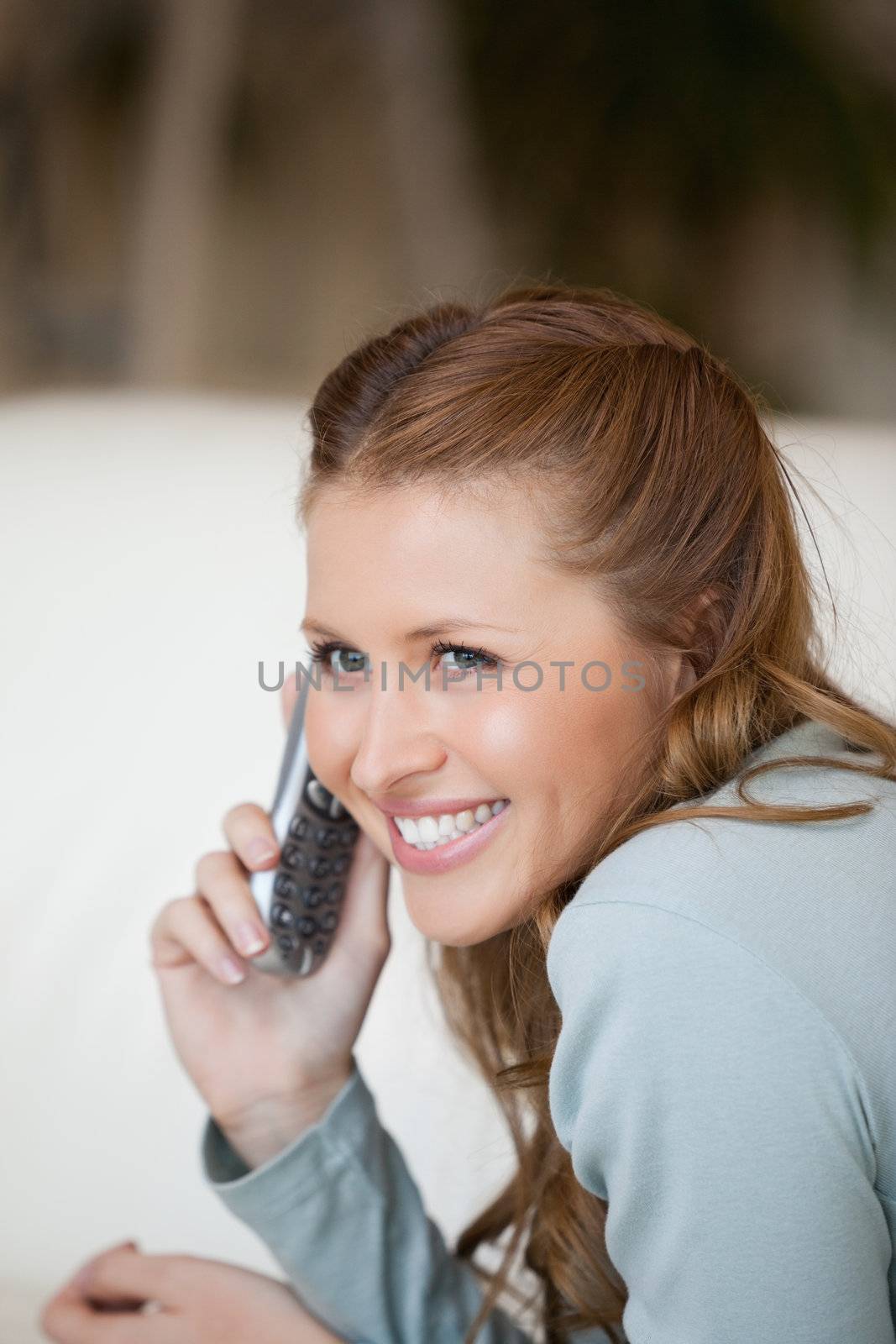 Woman smiling while phoning  by Wavebreakmedia