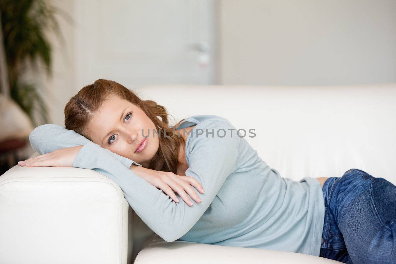Woman lying on a sofa while crossing her arms by Wavebreakmedia