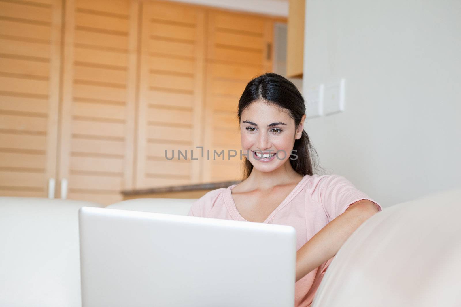 Woman smiling while using a computer indoor