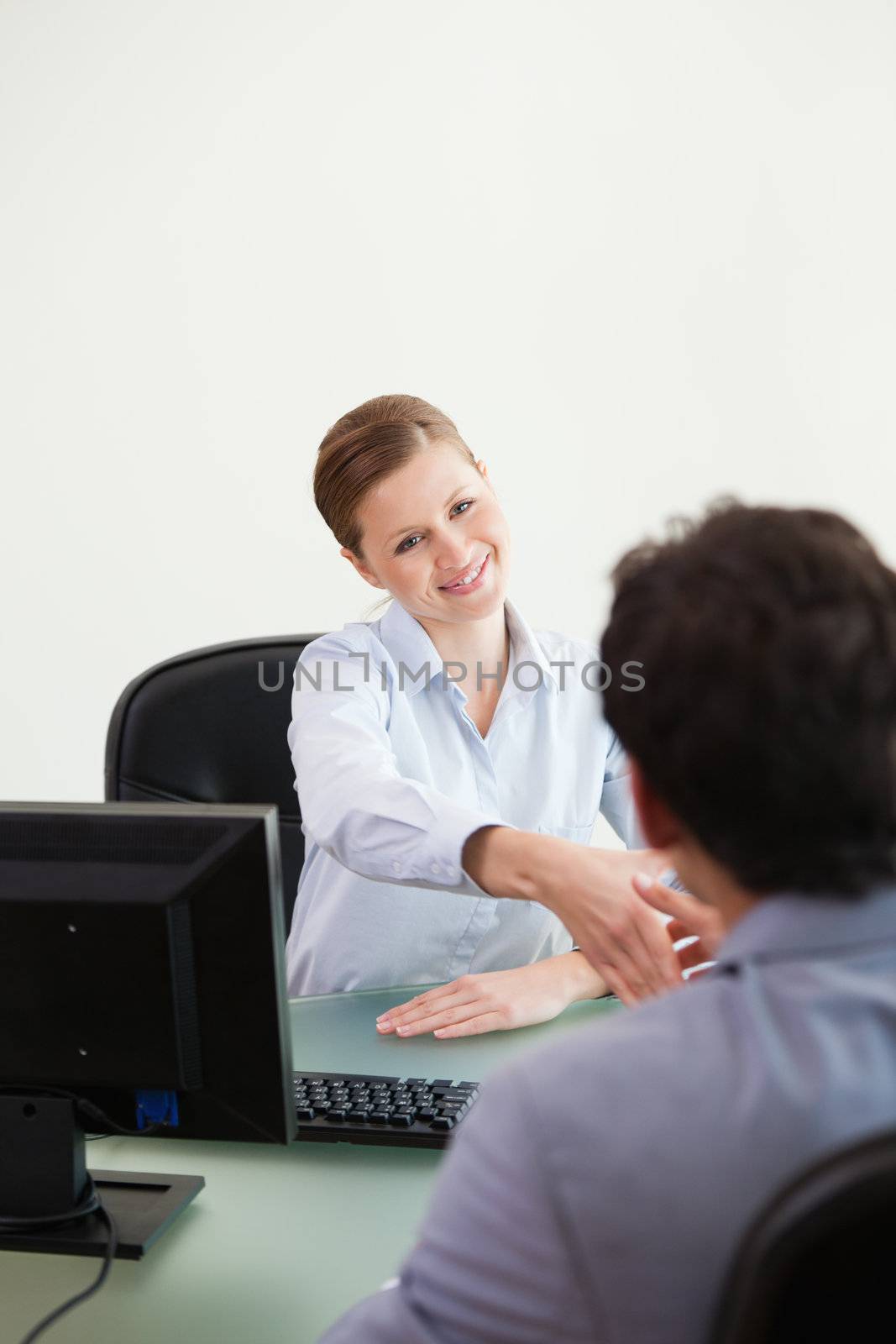Businesswoman shaking hand to her client against grey background