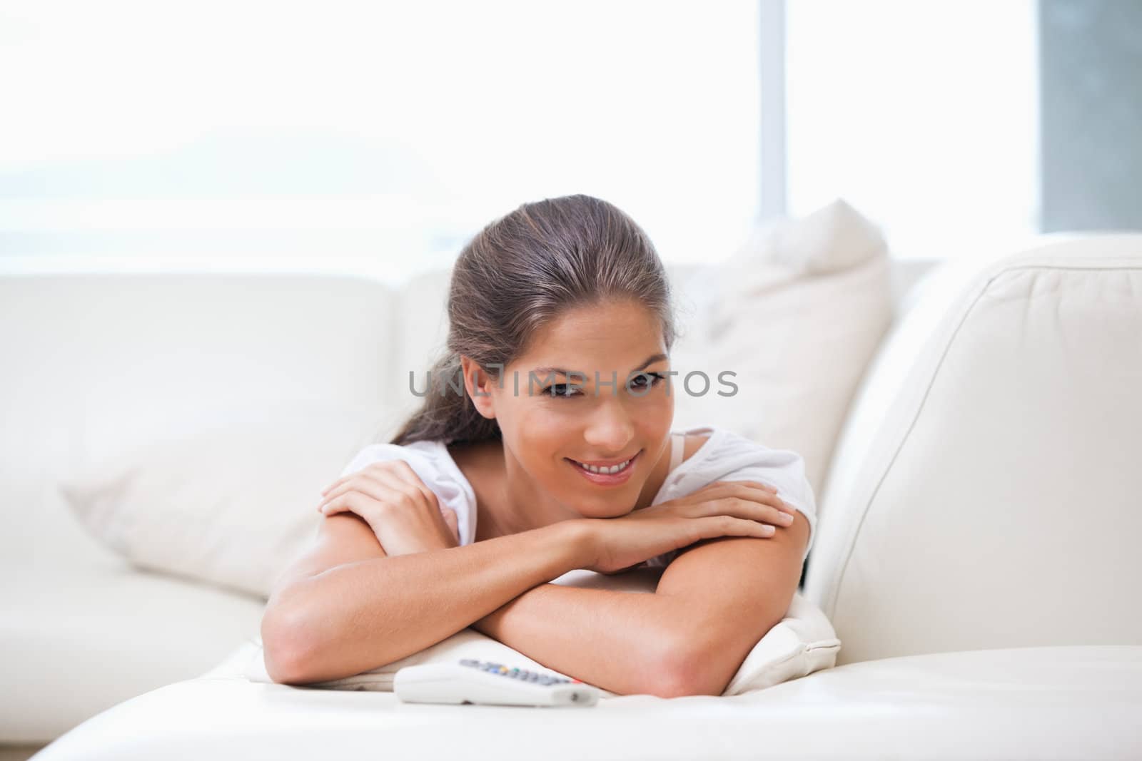 Woman smiling while lying on a sofa in a living room
