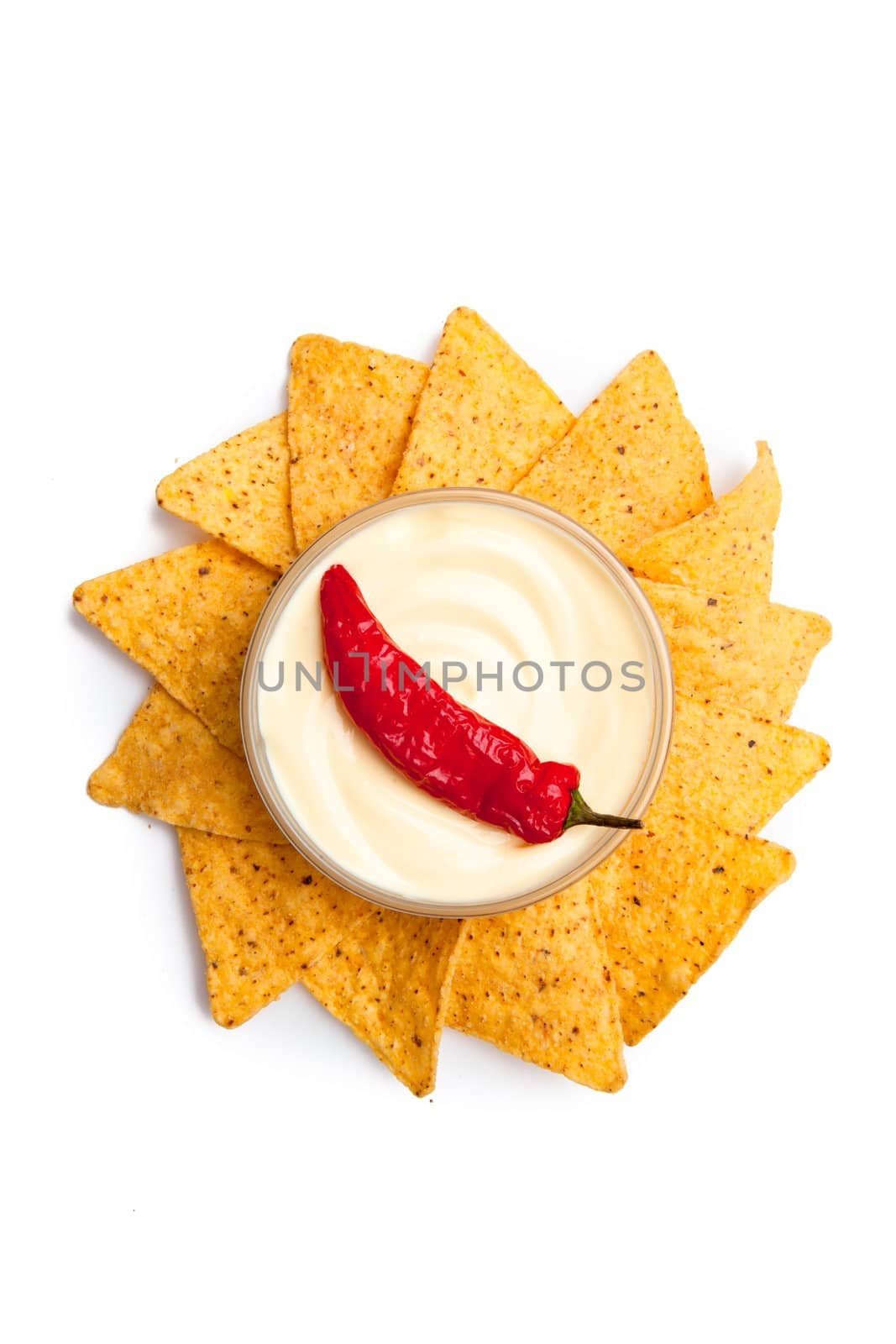 Pepper dipped into a bowl of white dip surrounded by nachos
