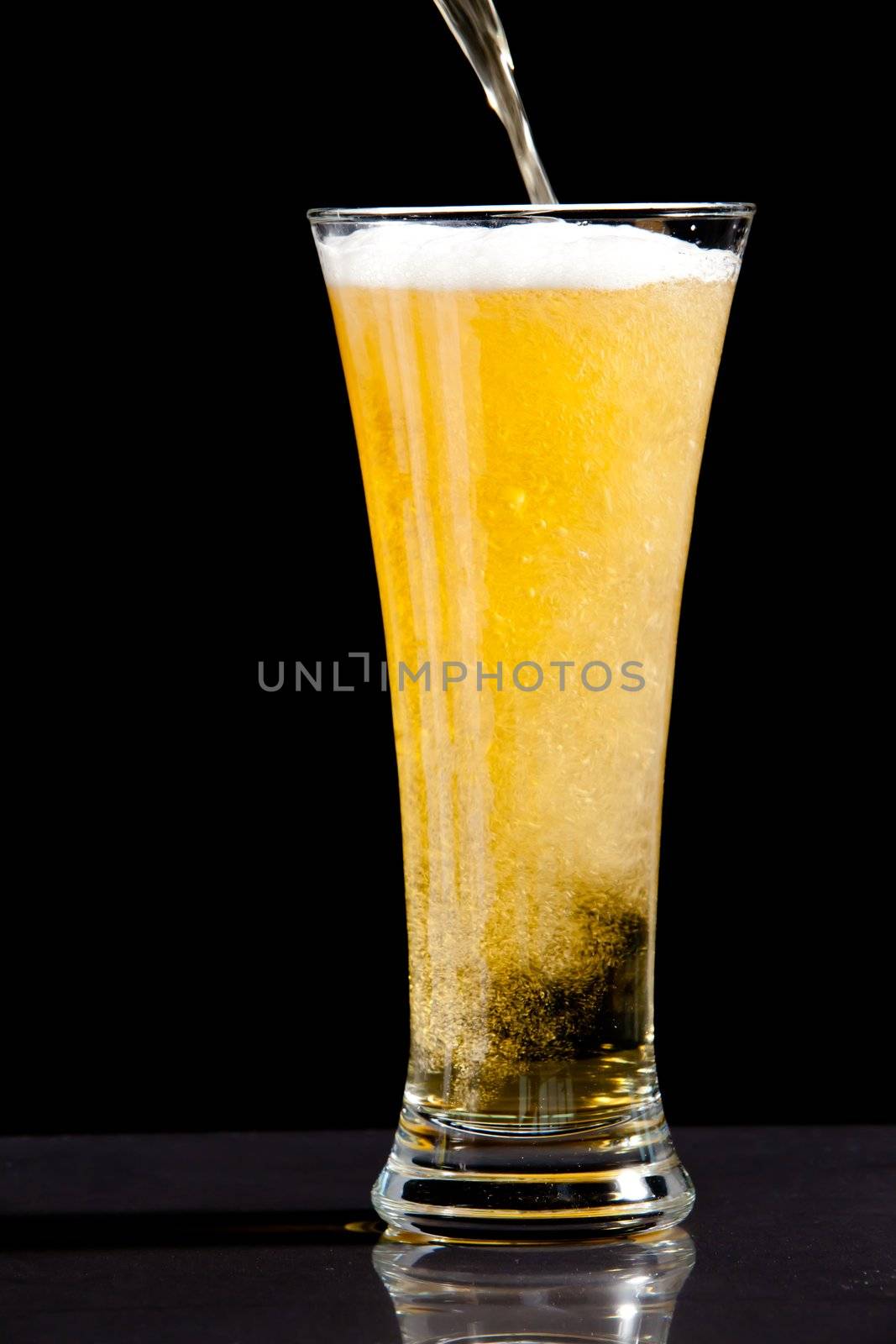 Glass finishing to be filled with beer against a black background