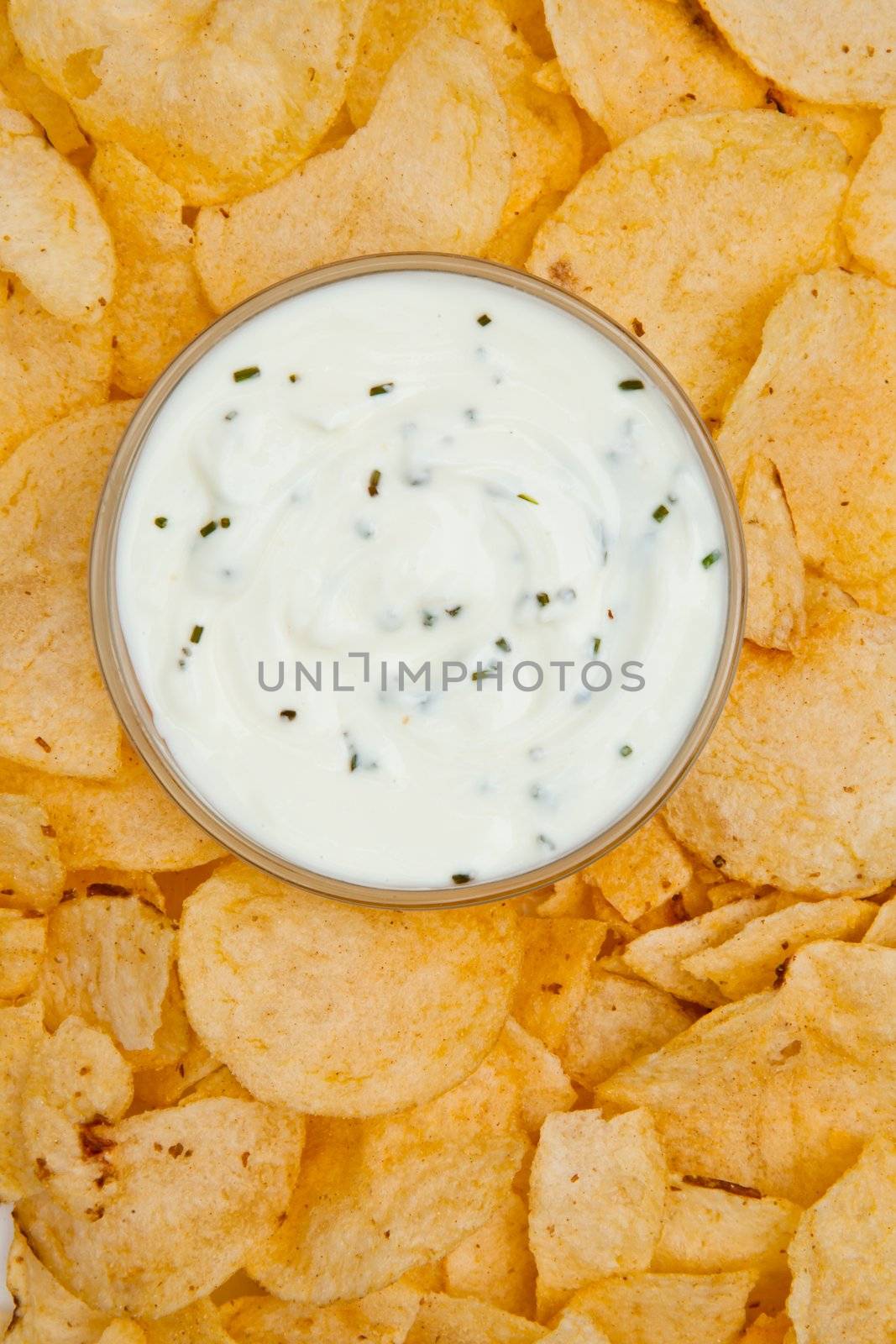 Close up of a bowl of white dip surrounded by nachos by Wavebreakmedia
