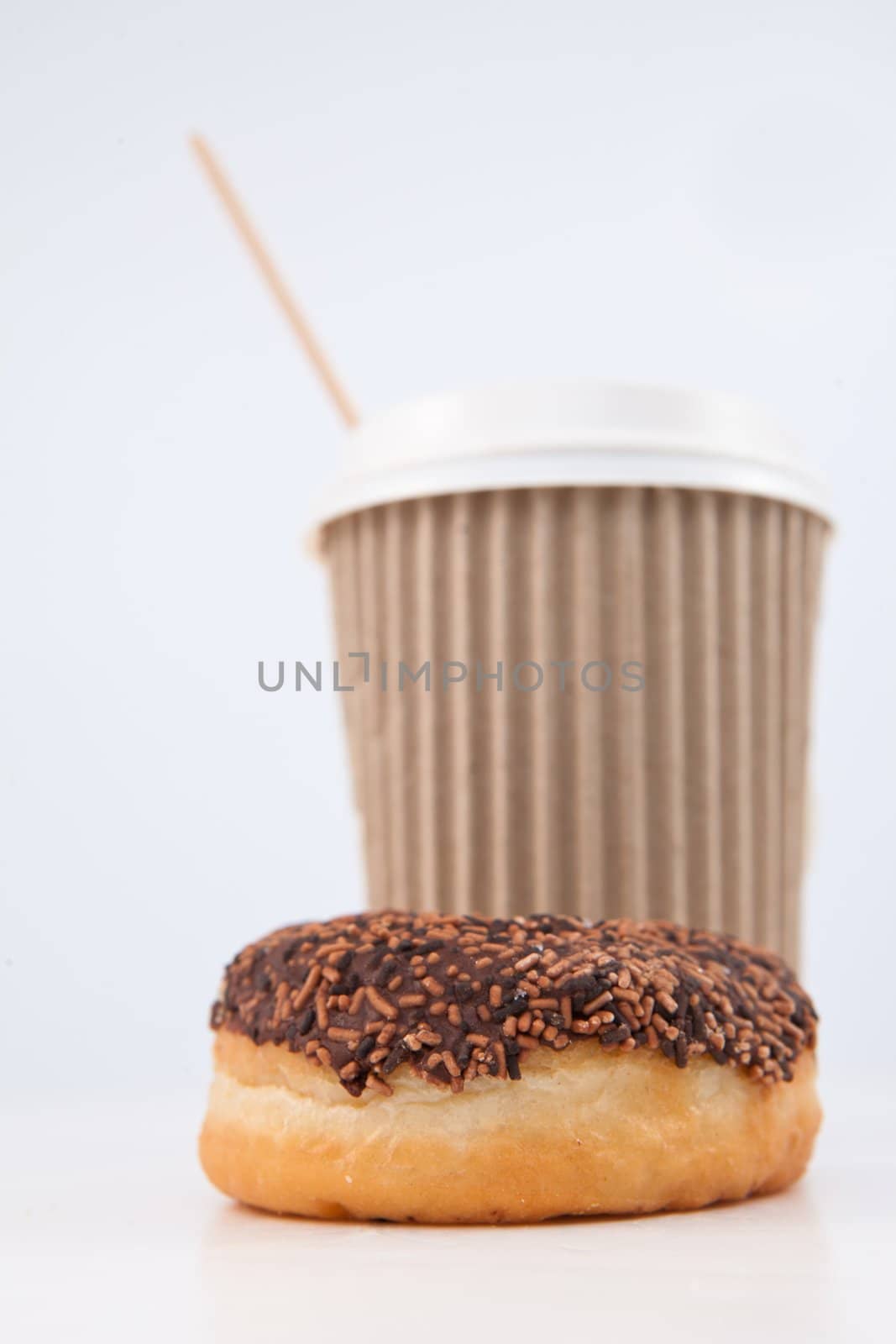 A doughnut and a cup of coffee placed together against a white background