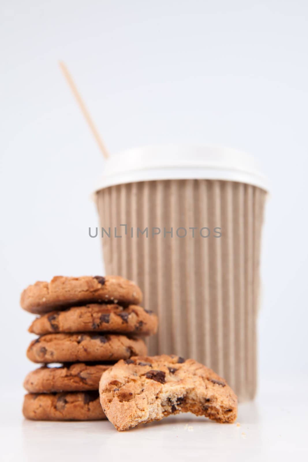 Five cookies and an half eaten cookie and a cup of coffee placed by Wavebreakmedia