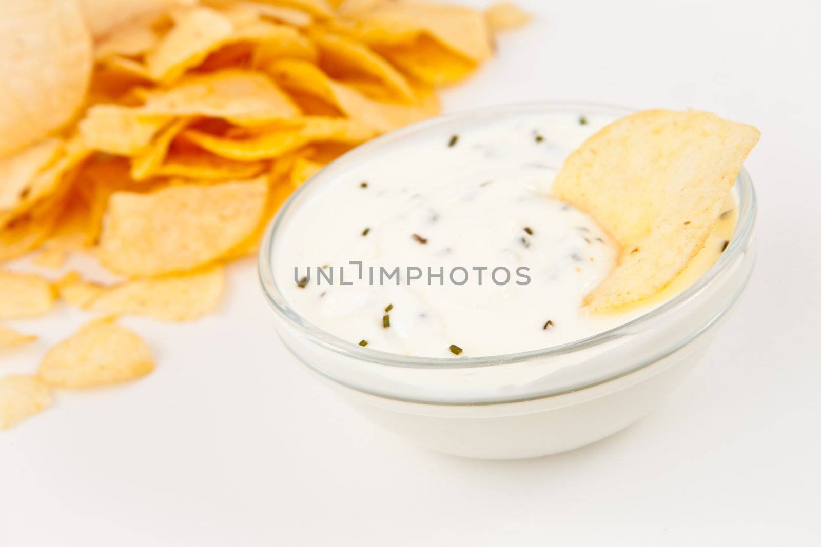 Bowl of  dip with herbs beside chips by Wavebreakmedia