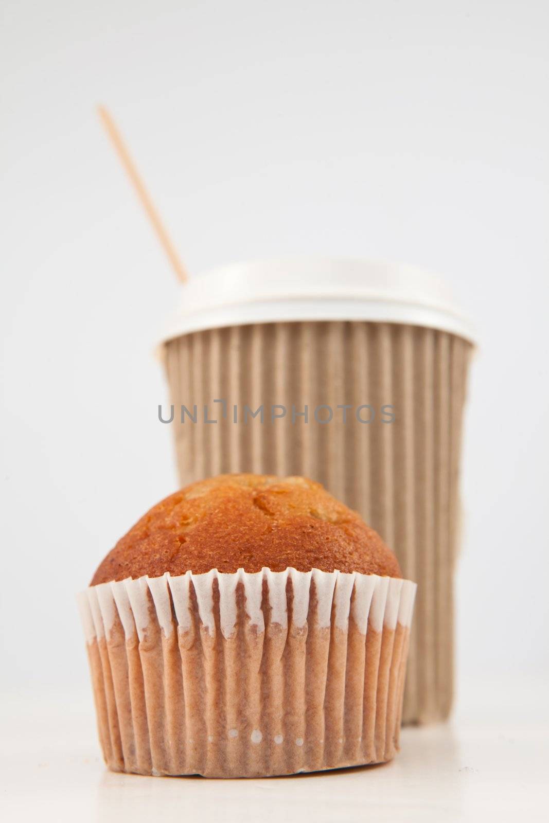 Muffin and cup of tea placed together against white back ground