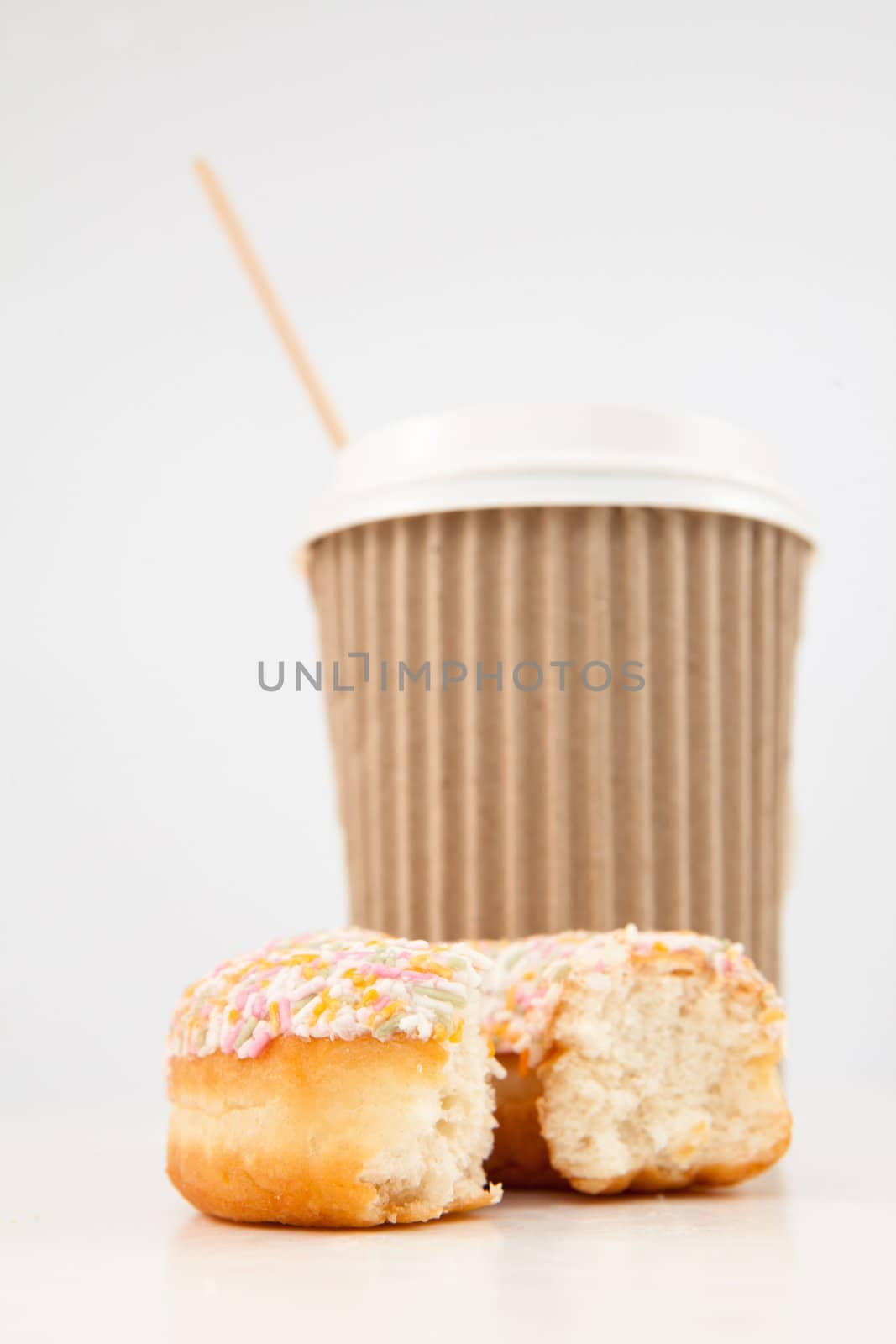 An half eaten doughnut and a cup of tea placed together by Wavebreakmedia