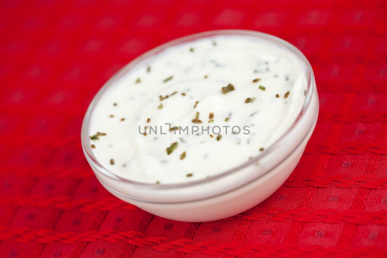 Bowl of white dip on a red tablecloth by Wavebreakmedia