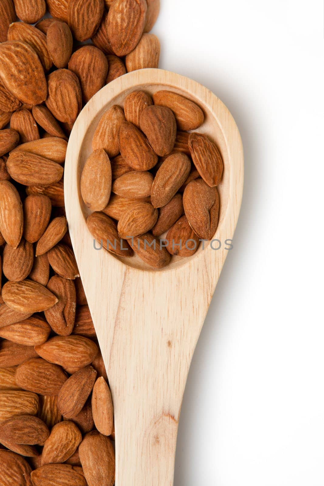 Wooden spoon traditional with almonds against a white background