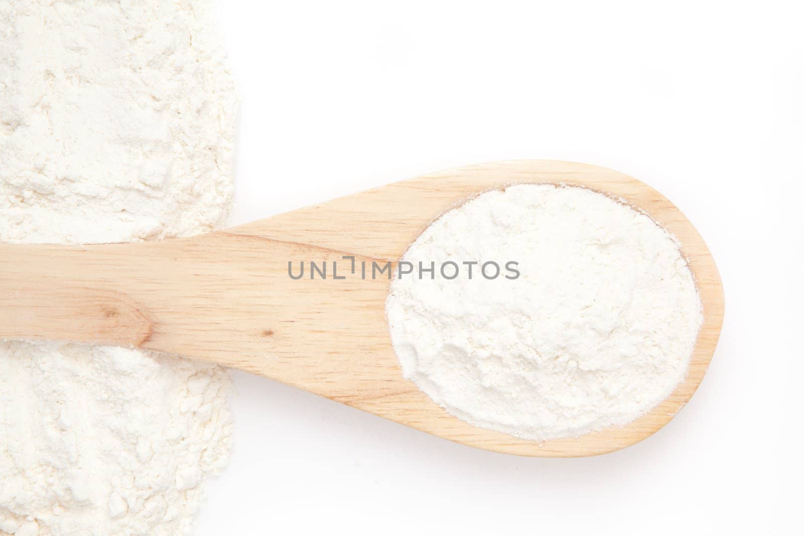 Wooden spoon with flour against a white background