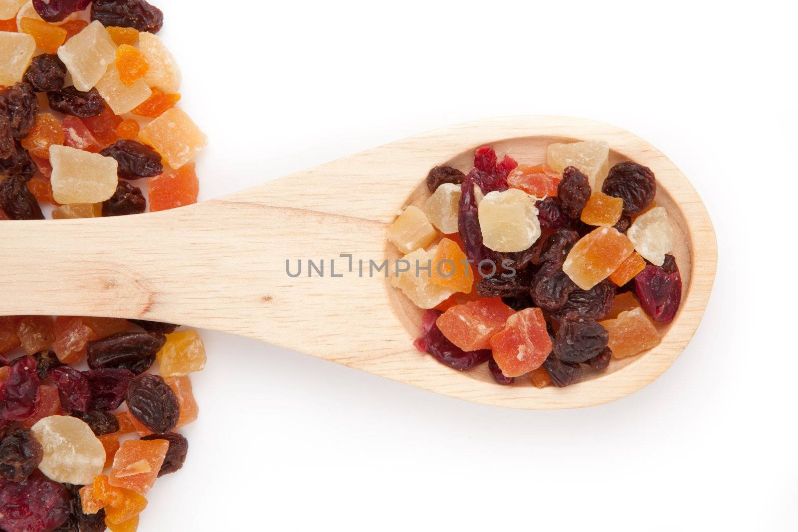 Wooden spoon with dried fruit against a white background
