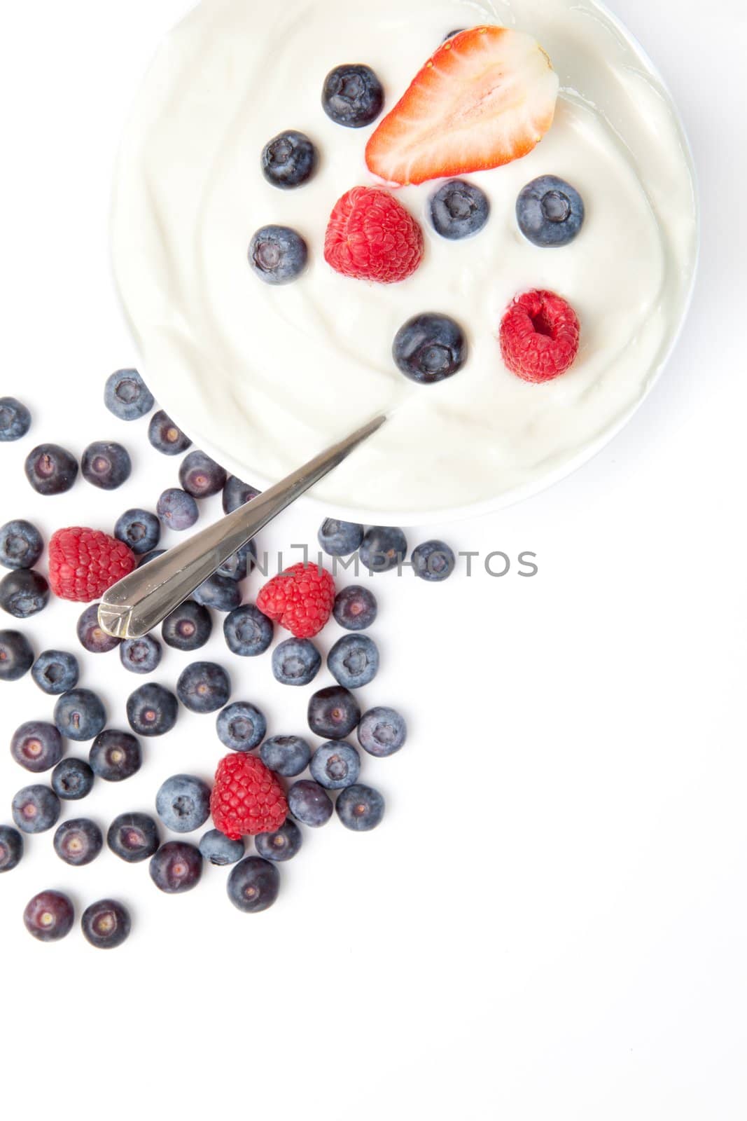 Bowl of cream with fruits  against a white background