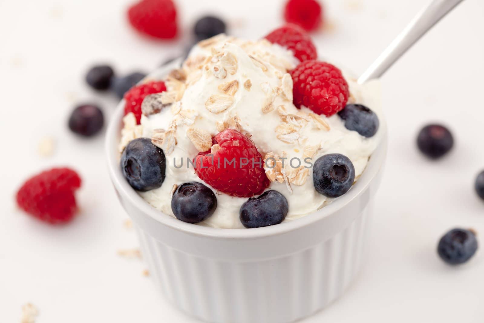 Sweet berries in whipped cream against white background